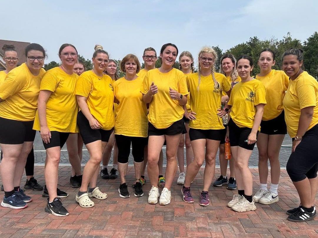 The Simply Sorted cleaning team in matching yellow t-shirts, standing together outdoors